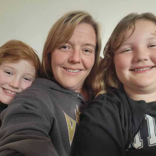 Charlie and Mathilda smile to camera with their mum, Joanna.