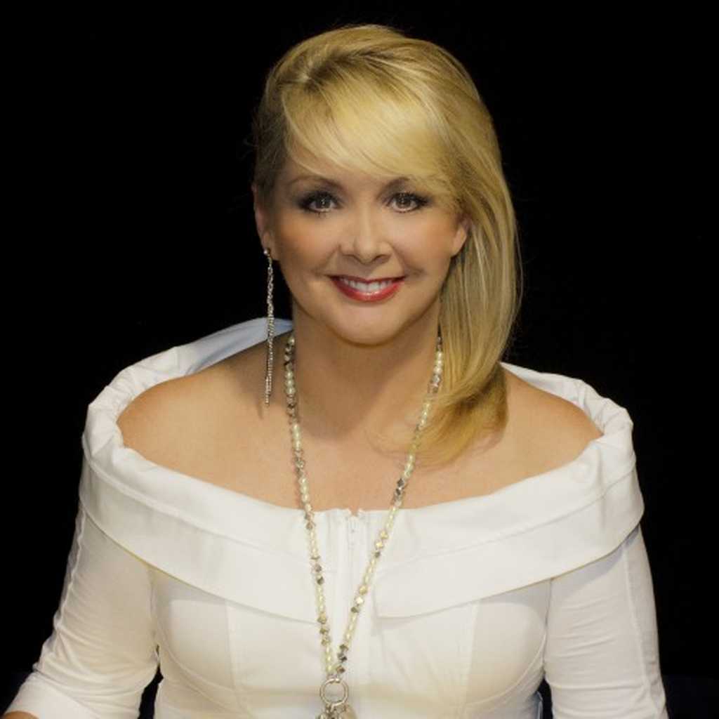 BWBF Patron Cheryl Baker smiles to camera. She is wearing a white top and her blonde hair is swept to one side.